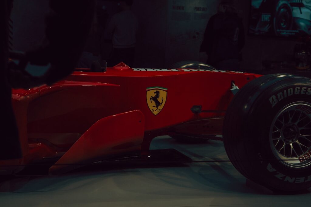 Red ferrari formula 1 car with yellow emblem
