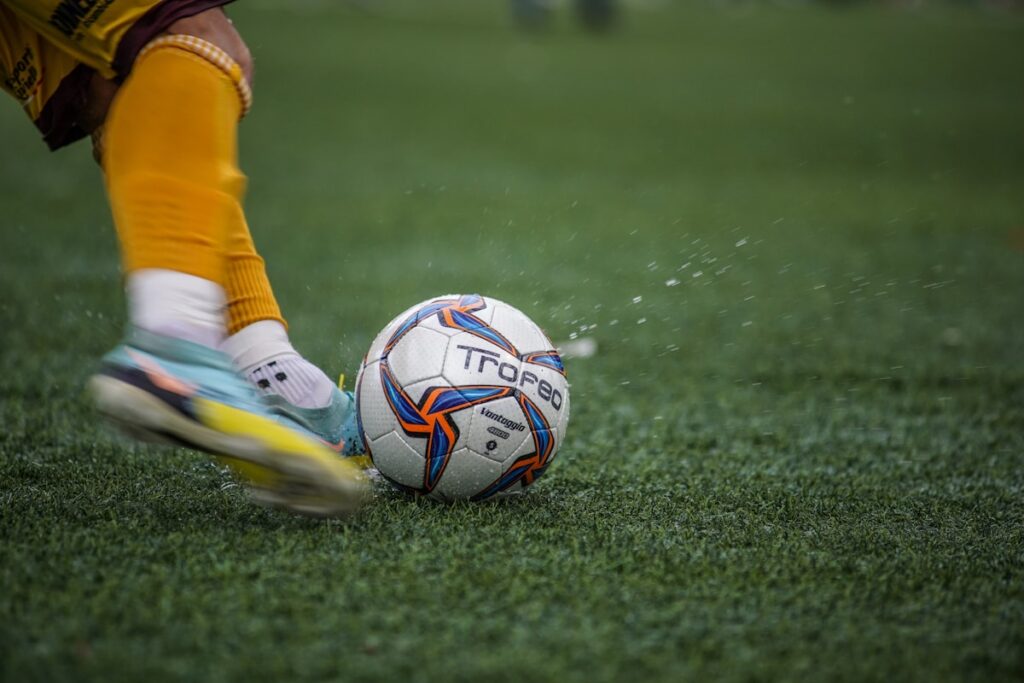a person kicking a soccer ball on a field